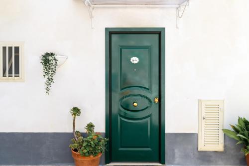 a green door on a white building with potted plants at Casa Gilda Positano in Positano