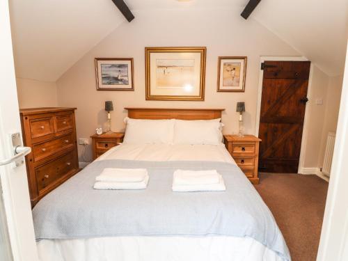 a bedroom with a bed with two towels on it at Capel Cottage in Penmaen-mawr