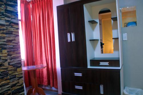 un placard avec un miroir et un rideau rouge dans l'établissement Hotel Virgen del Carmen - Huaraz, à Huaraz