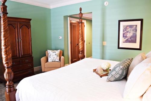 a bedroom with a bed with a dresser and a chair at JH Adams Inn, Trademark Collection by Wyndham in High Point