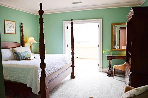 a bedroom with green walls and a bed and a doorway at JH Adams Inn, Trademark Collection by Wyndham in High Point