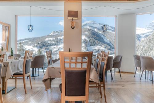 a dining room with a table and views of mountains at Hotel Chalet Dlaces in Selva di Val Gardena