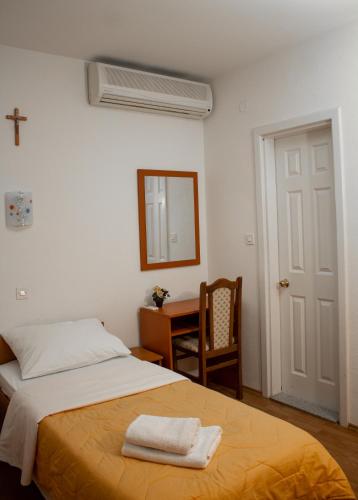 a bedroom with a bed and a mirror and a desk at Pansion Milena in Međugorje