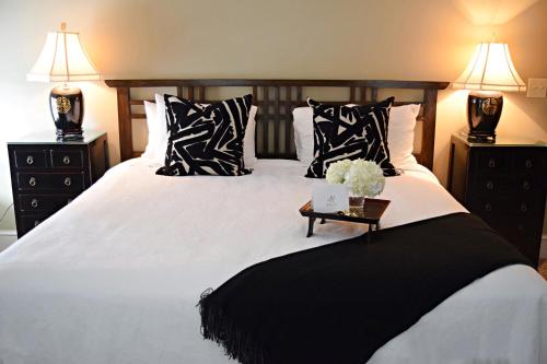 a bed with black and white pillows and a table at JH Adams Inn, Trademark Collection by Wyndham in High Point
