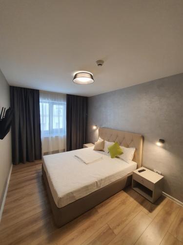 a bedroom with a large bed and a window at Aparthotel Nevada - Apartamente in Constanţa