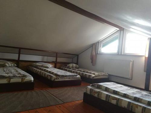 three beds in a room with a window at Casa Riciu in Buşteni
