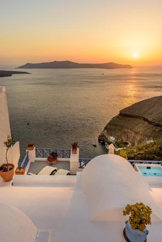 a view of the ocean at sunset from a house at Golden Grey Goose in Fira