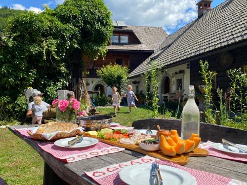 una mesa de picnic con comida en un patio en Apartmaji Katrnjek, en Bohinj