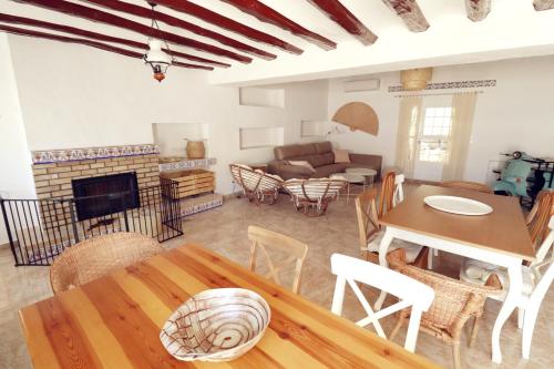 a living room with a table and a fireplace at Meravella Casa Rural in Tinajeros
