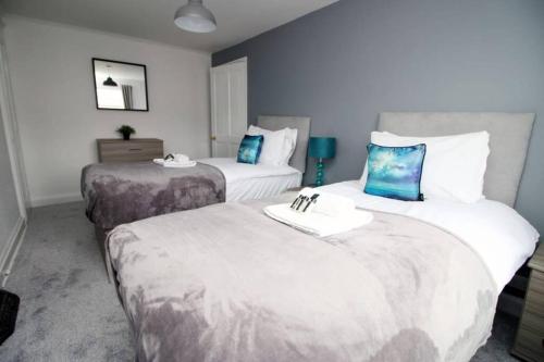 two beds in a hotel room with white and blue pillows at 3Bedroom Georgian Apartment, 5 beds, 5 mins from Bath Abbey in Bath