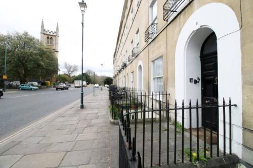 a building with a black door on the side of a street at 3Bedroom Georgian Apartment, 5 beds, 5 mins from Bath Abbey in Bath