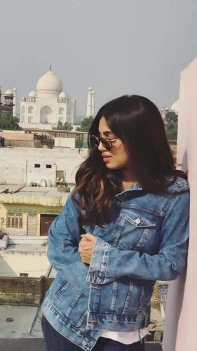 a woman in a denim jacket standing in front of a building at Hotel Kamal Nearest To Taj Mahal in Agra