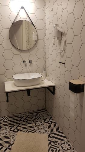 a bathroom with a sink and a mirror at Mieszkanie w Kamienicy 4C in Pasłęk