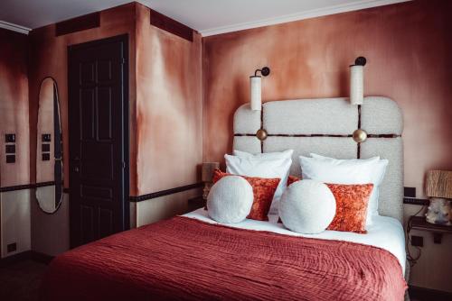 - une chambre avec un grand lit, une couverture rouge et des oreillers dans l'établissement Babel Belleville, à Paris