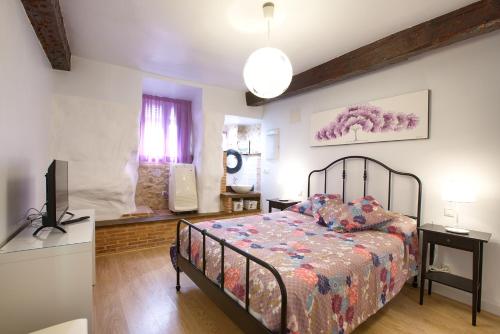 Un dormitorio con una cama y un televisor. en Cuencaloft Calderón de la Barca, en Cuenca
