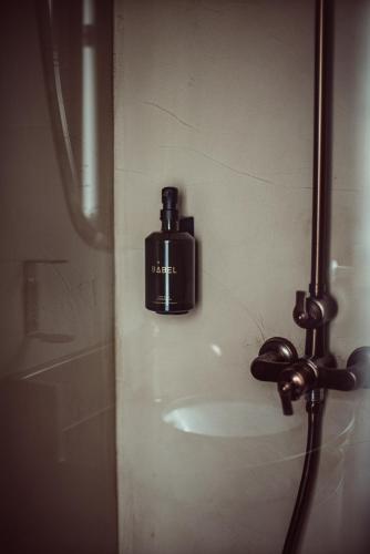 a soap dispenser on the wall of a shower at Babel Belleville in Paris