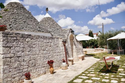 a stone building with a stone wall and some plants at Trulli Pastore in Alberobello