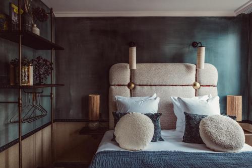 a bedroom with a bed with a large headboard and pillows at Babel Belleville in Paris