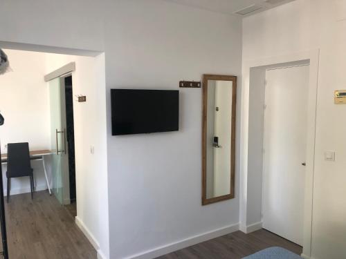 a white room with a television on a wall at La Estación in Sanlúcar de Barrameda