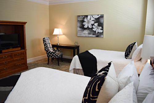 a hotel room with two beds and a television at JH Adams Inn, Trademark Collection by Wyndham in High Point