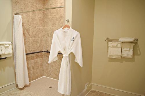 a robe hanging in a shower in a bathroom at JH Adams Inn, Trademark Collection by Wyndham in High Point
