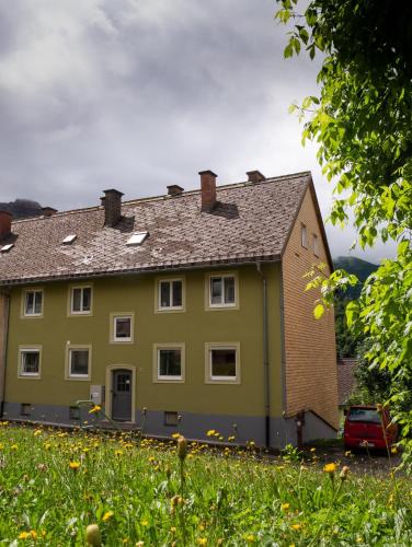 a yellow house with a car parked in front of it at Eisenerz Stefan Apartment / Ferien Wohnung in Eisenerz