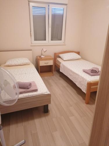a room with two beds and a nightstand and two windows at Salona Croatia in Solin