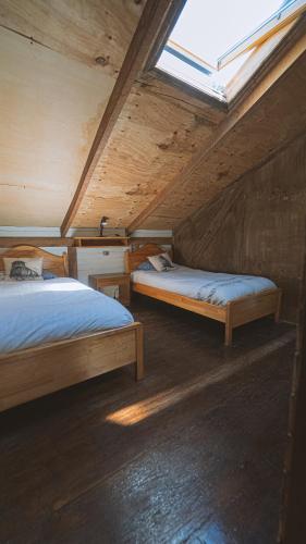 two beds in a room with a window at Hostal Climb House in Puerto Varas