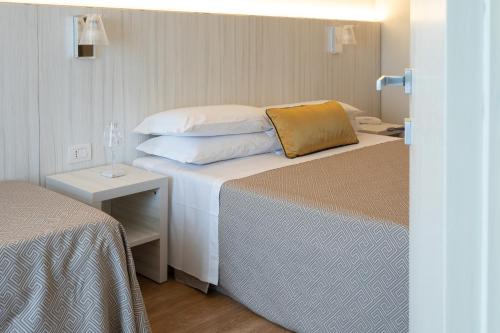 a hotel room with two beds and a table at Hotel La Nuova Rotaia in Gallarate