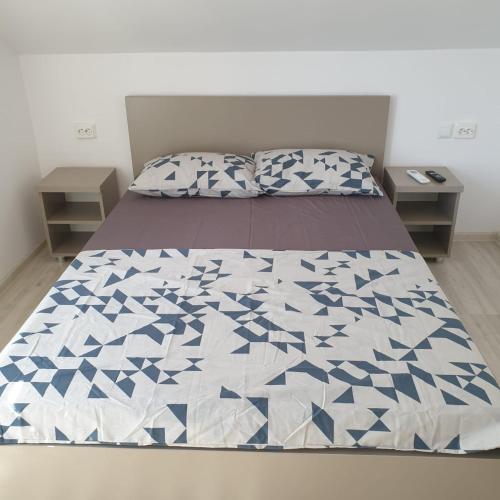 ein Schlafzimmer mit einem Bett mit einer blau-weißen Decke in der Unterkunft Casa Margareta in Eforie Sud