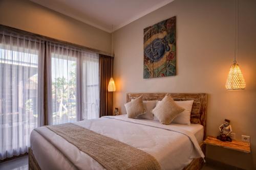 a bedroom with a large bed and a large window at Kubu Dimel Suites and Villas Resort in Nusa Dua