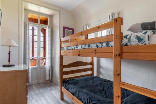 - une chambre avec 2 lits superposés et un bureau dans l'établissement Maison avec beau jardin - Centre ville d'Arromanches, à Arromanches-les-Bains