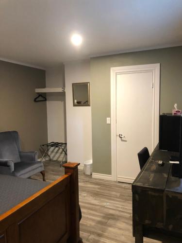 a room with a bed and a living room with a door at Greenside Motel in Saint Andrews