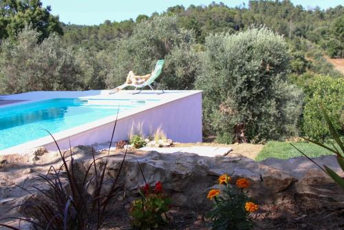 a chair sitting next to a swimming pool at Lameira Da Longra - Wellness Retreat in Tomar