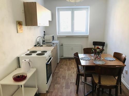 une cuisine avec une table et une petite cuisine avec une cuisinière dans l'établissement Apartmán Ala, à Spišská Nová Ves