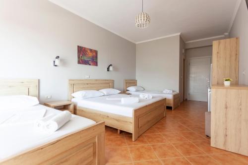 a bedroom with two beds and a chandelier at Toni Retzo Rooms in Himare