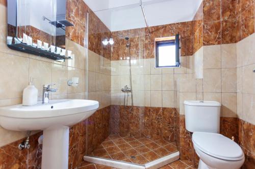 a bathroom with a toilet and a sink and a shower at Toni Retzo Rooms in Himare