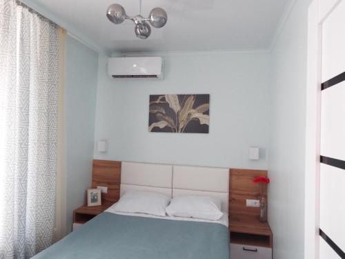 a small bedroom with a bed with a blue blanket at Esil Plaza Apartment in Astana