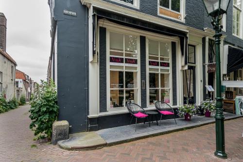 two pink chairs sitting in front of a store at Slapen bij Van-V in Zierikzee
