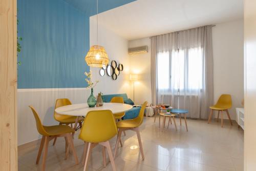 a dining room with a table and yellow chairs at Atmosfera Salento in Salice Salentino