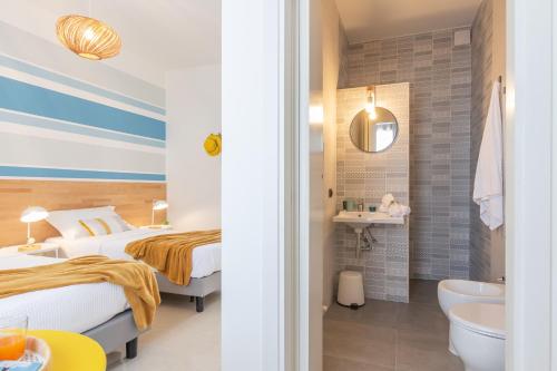 a hotel room with two beds and a bathroom at Atmosfera Salento in Salice Salentino