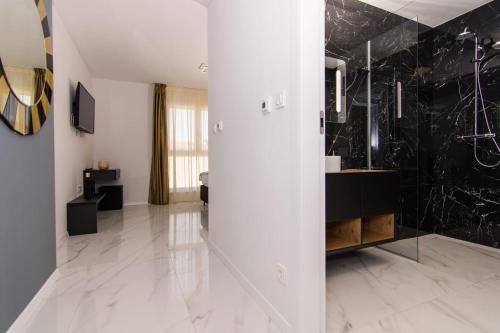 uma casa de banho com uma parede em mármore preto e branco em Mia em Trogir