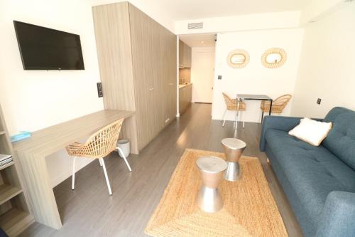 un salon avec un canapé bleu et une table dans l'établissement Beautiful studio at the Grand Hotel Residence with sunny balcony 138, à Cannes