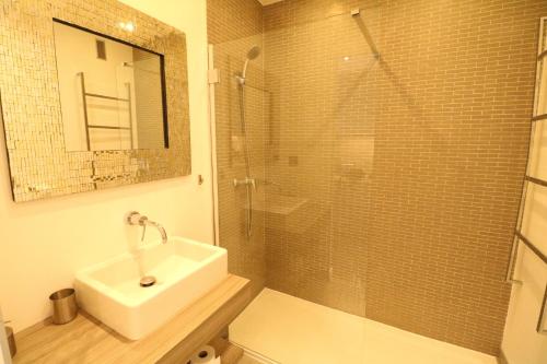 une salle de bain avec un lavabo et une douche en verre dans l'établissement Beautiful studio at the Grand Hotel Residence with sunny balcony 138, à Cannes
