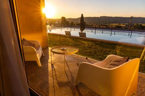 a view from a balcony with chairs and a table at LOBOS VILLAGE - Alojamento in Seia