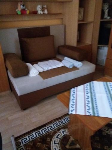 Cama pequeña en una sala de estar con mesa en Apartament Nicoleta, en Jurilovca