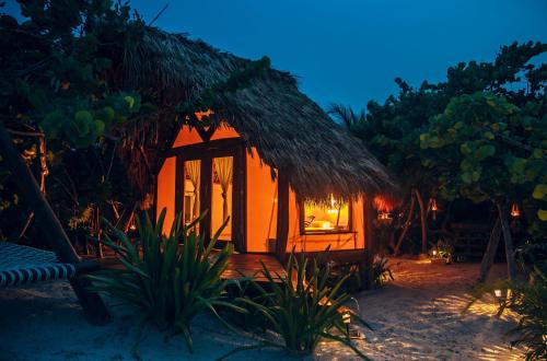a small hut on the beach at night at Glamp Ikal Tulum in Tulum