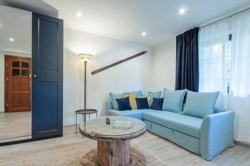 a living room with a blue couch and a table at Dworek Pod Jodłami in Zakopane