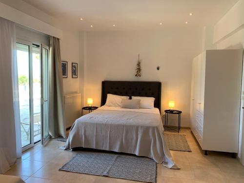 a bedroom with a bed with two lamps on two tables at Swash & Ripple Studio by the sea in Mytikas