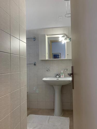 a bathroom with a sink and a mirror at Swash & Ripple Studio by the sea in Mytikas